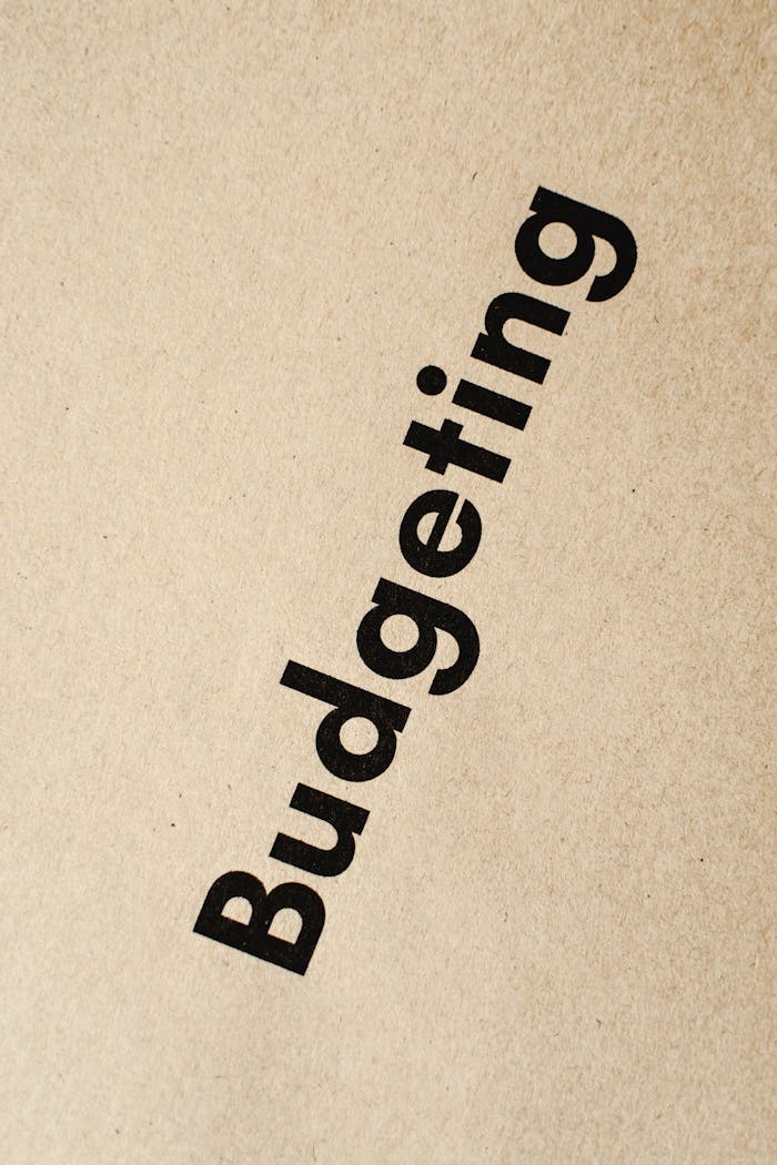 Detailed close-up of the word Budgeting printed on brown textured paper.
